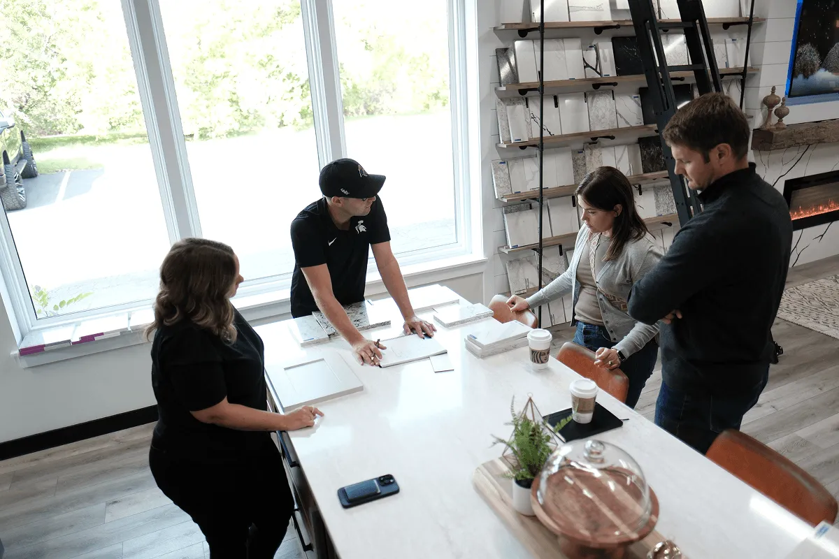 O’Leary Interiors designers meeting with clients around a showroom island with countertop samples