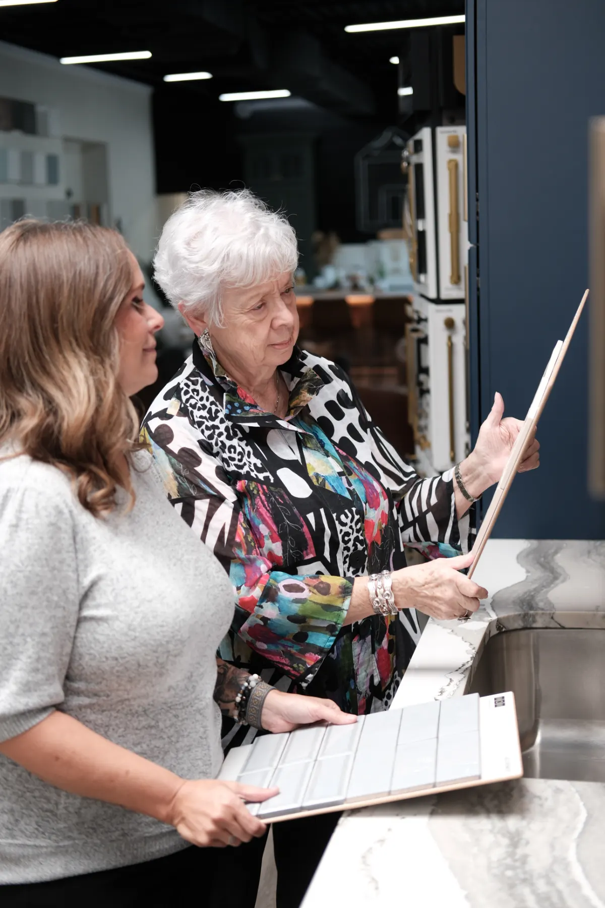 Marilyn Wakefield and Heidi Sommer reviewing tile samples in the O’Leary Interiors showroom